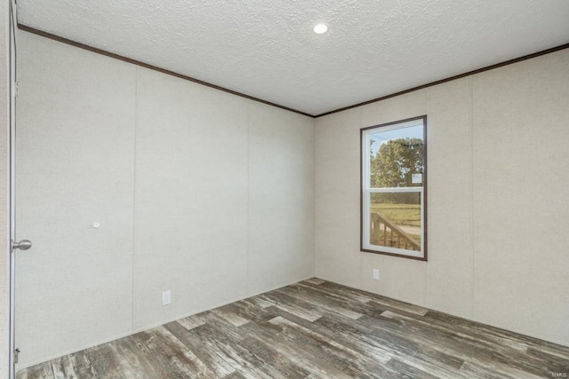 unfurnished room featuring crown molding, a textured ceiling, and wood finished floors