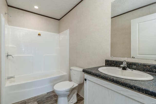 bathroom with toilet, vanity, wood finished floors, a textured ceiling, and shower / bathtub combination