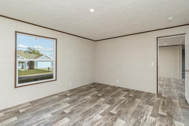 unfurnished bedroom with a textured ceiling, ornamental molding, and wood finished floors