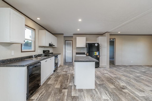 kitchen with a center island, dark countertops, white cabinets, a sink, and black appliances