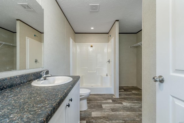 bathroom with a stall shower, visible vents, wood finished floors, a textured ceiling, and vanity