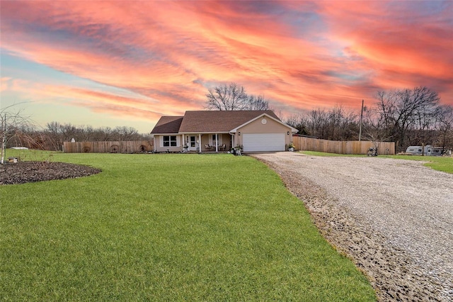 view of front of property featuring a garage, a lawn, and covered porch