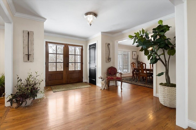 entrance foyer with french doors, crown molding, baseboards, and wood finished floors