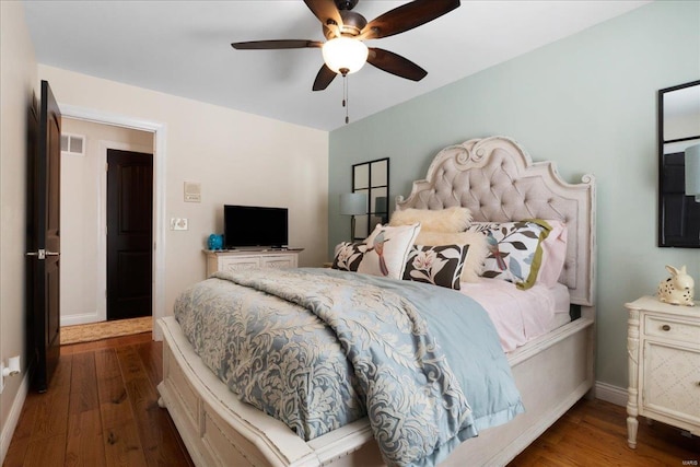 bedroom featuring visible vents, wood finished floors, a ceiling fan, and baseboards