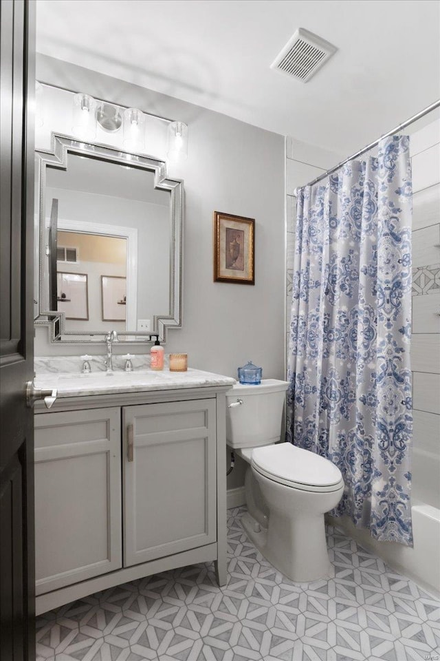 bathroom with visible vents, vanity, toilet, and shower / bath combo with shower curtain