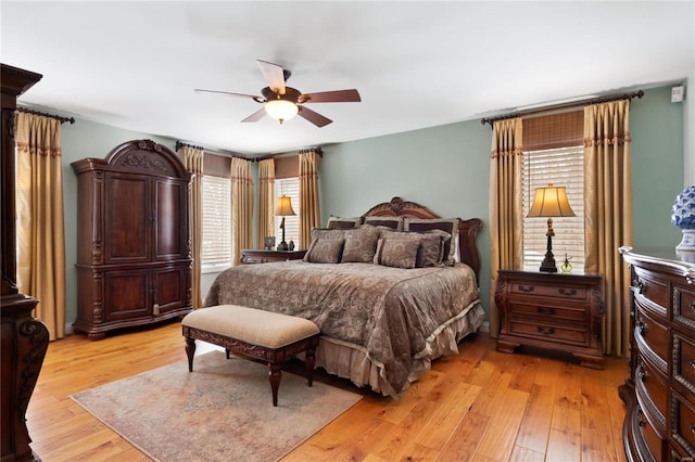 bedroom with light wood finished floors, multiple windows, and a ceiling fan