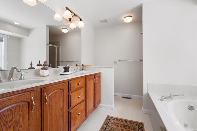 full bath with double vanity, baseboards, visible vents, a bath, and a sink