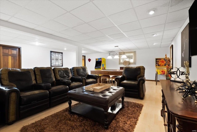 living area with light wood finished floors and a paneled ceiling