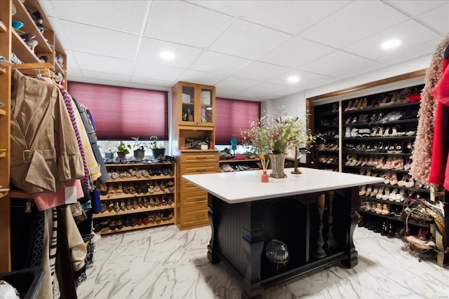 wine room featuring recessed lighting, marble finish floor, and a drop ceiling