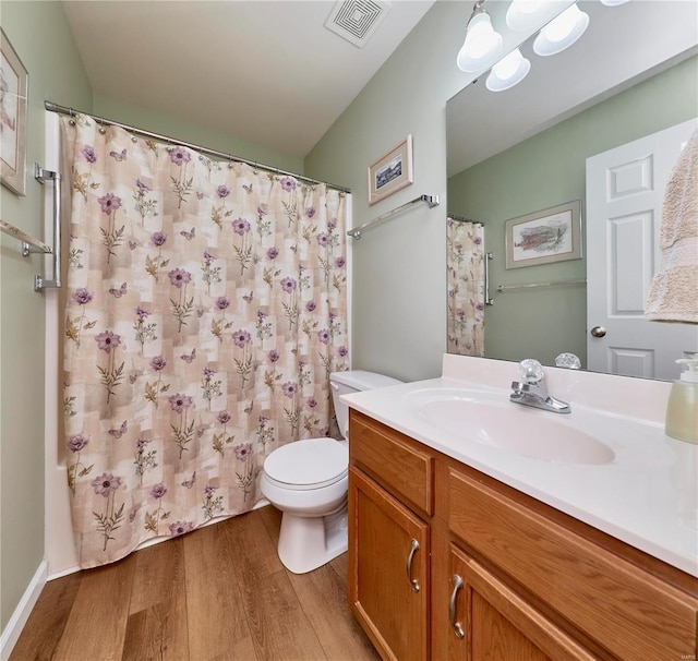 full bathroom featuring vanity, hardwood / wood-style flooring, toilet, and shower / bath combo with shower curtain