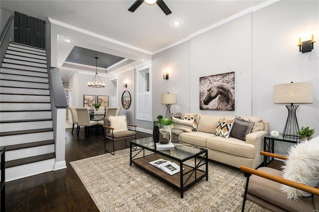 living room with crown molding, ceiling fan with notable chandelier, and dark hardwood / wood-style flooring