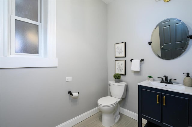 bathroom with hardwood / wood-style flooring, vanity, and toilet