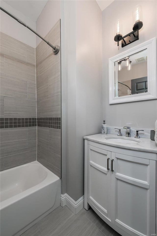 bathroom featuring tiled shower / bath and vanity