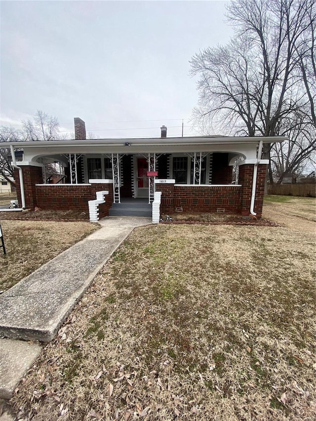 ranch-style home with a front yard and covered porch