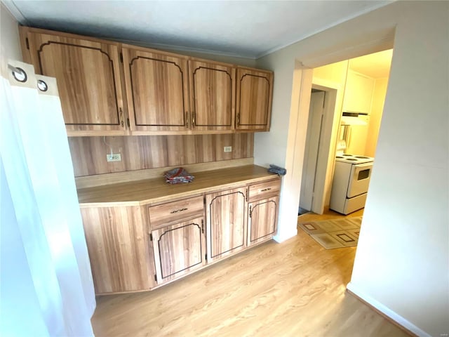 kitchen featuring ornamental molding, light hardwood / wood-style flooring, and electric stove