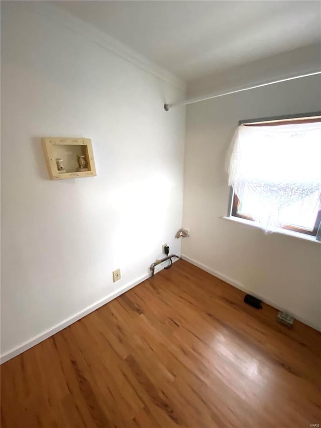 clothes washing area featuring washer hookup, hookup for a gas dryer, crown molding, and wood-type flooring