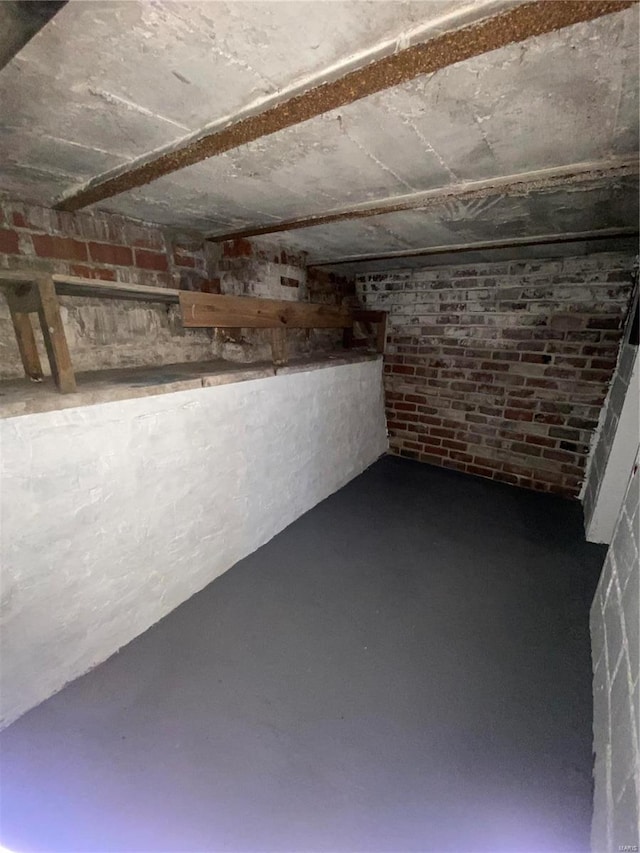 basement featuring brick wall