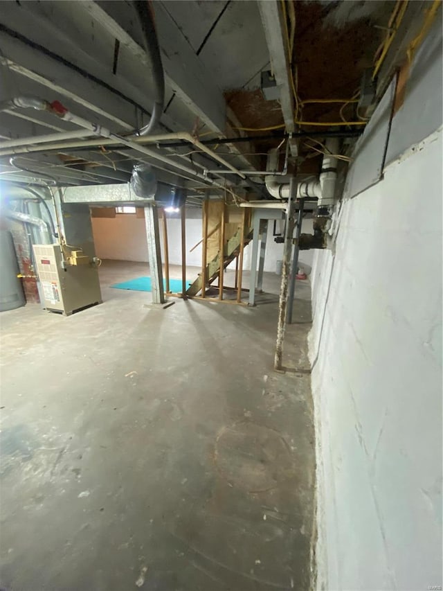 basement featuring heating unit and water heater