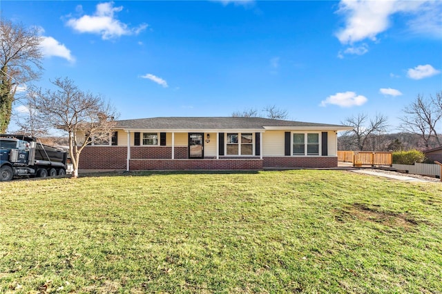 view of front of house with covered porch, fence, a front lawn, and brick siding