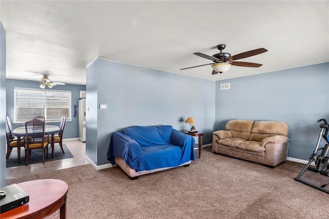 carpeted living area with ceiling fan, visible vents, and baseboards