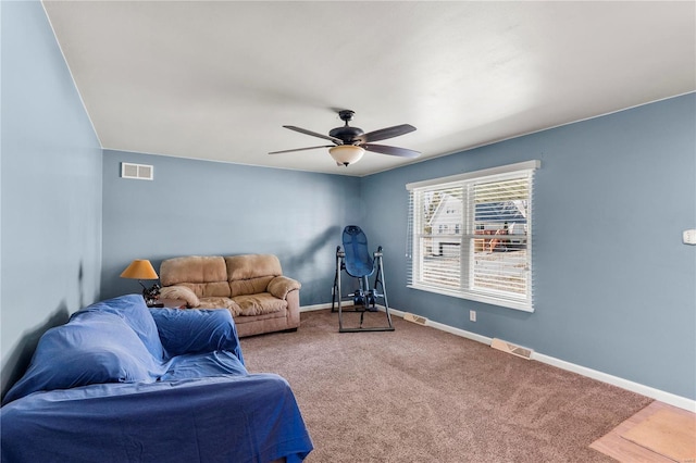 living area featuring visible vents, baseboards, ceiling fan, and carpet flooring