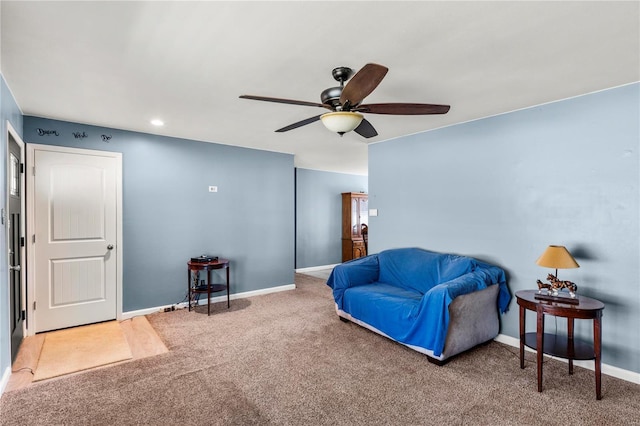 carpeted living room with a ceiling fan and baseboards