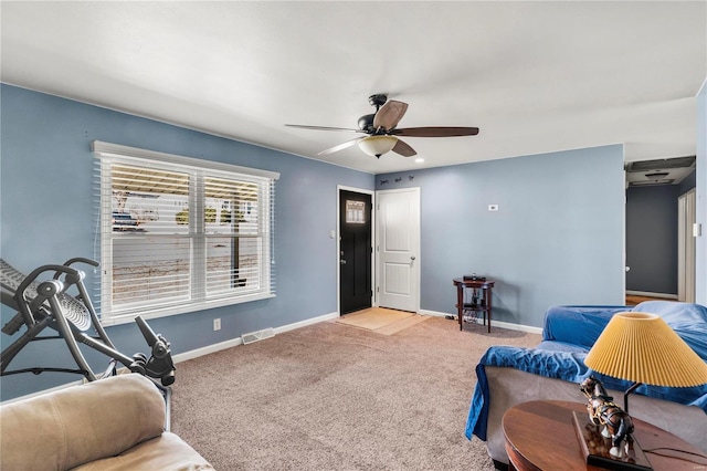 living area with carpet floors, visible vents, baseboards, and a ceiling fan