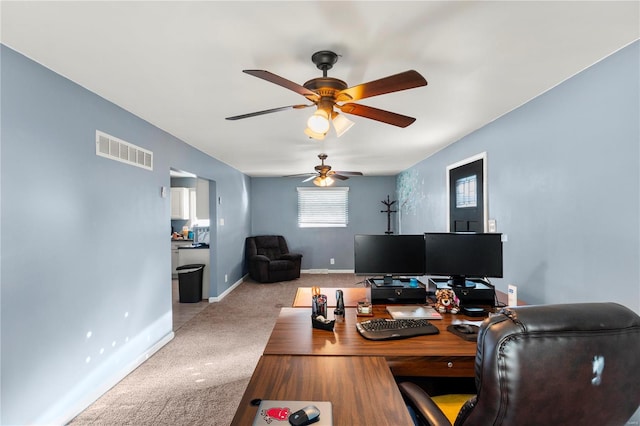 carpeted office space featuring baseboards, visible vents, and a ceiling fan