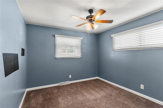 spare room featuring carpet floors, visible vents, ceiling fan, and baseboards