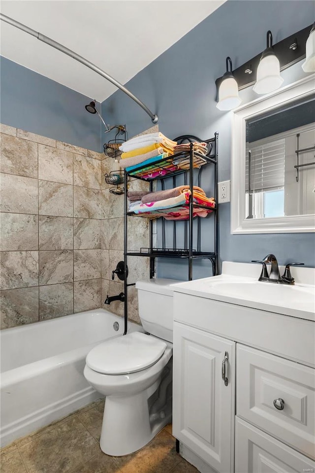 bathroom featuring toilet, tile patterned flooring, vanity, and bathing tub / shower combination