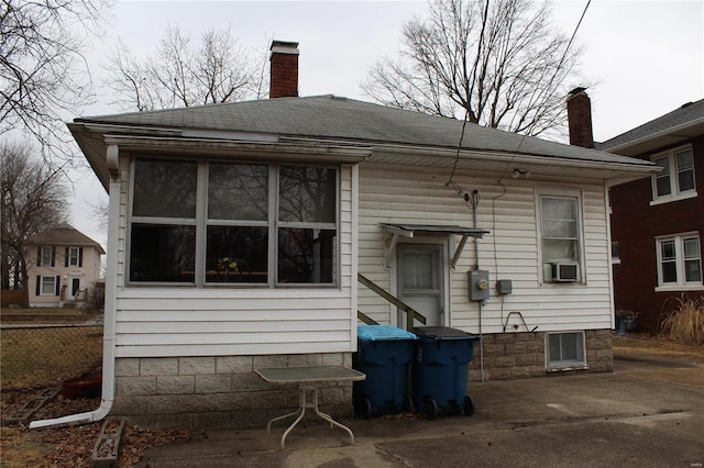 back of property featuring a shingled roof, a chimney, a patio area, and cooling unit