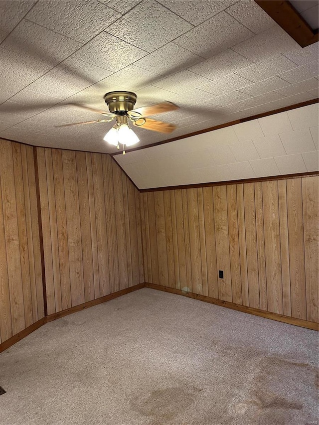 additional living space with light carpet and wooden walls