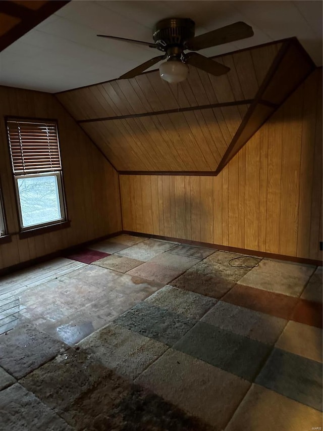 additional living space featuring lofted ceiling, wooden walls, and ceiling fan