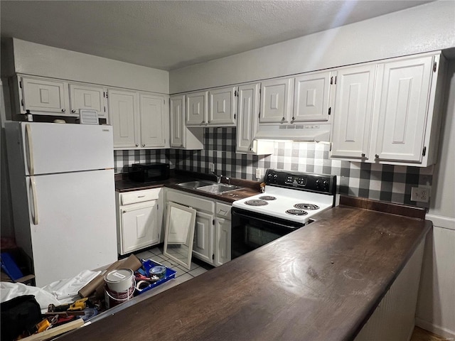 kitchen with freestanding refrigerator, under cabinet range hood, white cabinetry, a sink, and range with electric stovetop