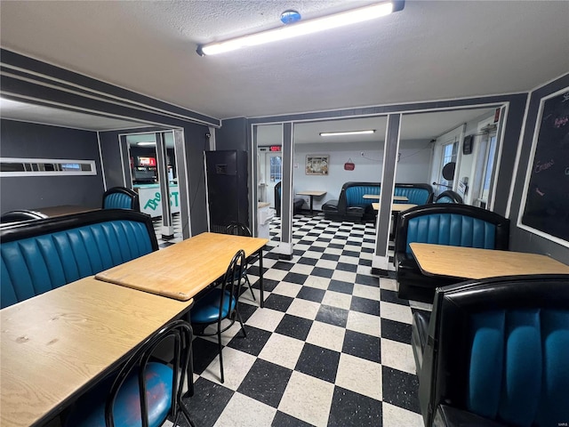 dining room featuring a textured ceiling and tile patterned floors