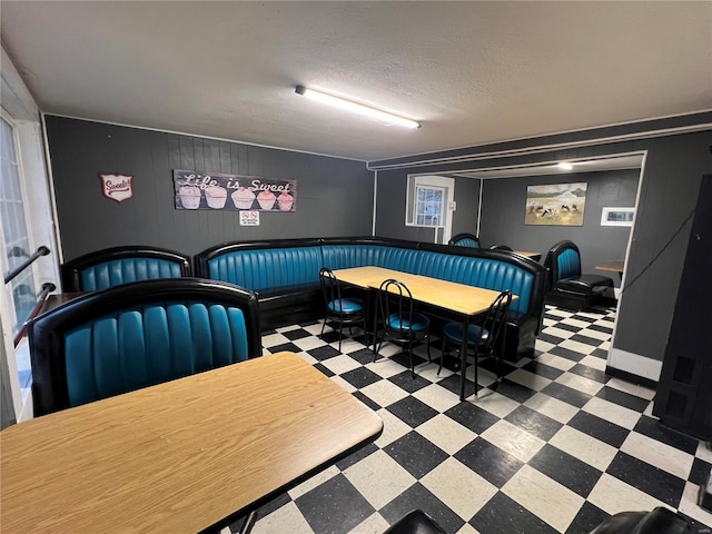 dining space with a textured ceiling and tile patterned floors