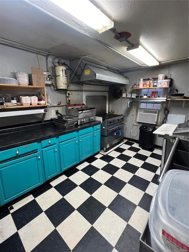 kitchen with open shelves, blue cabinetry, a wall mounted AC, light floors, and dark countertops