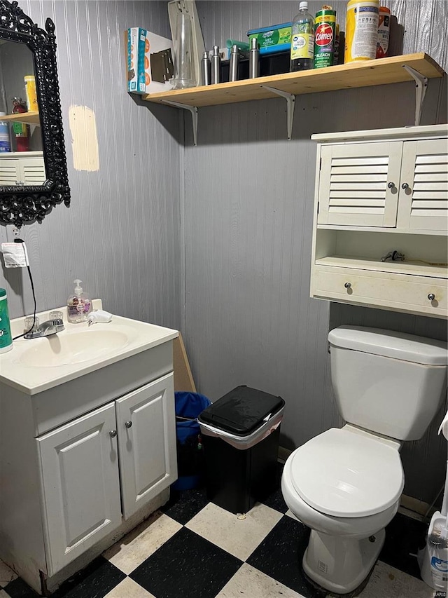 half bath with vanity, toilet, and tile patterned floors