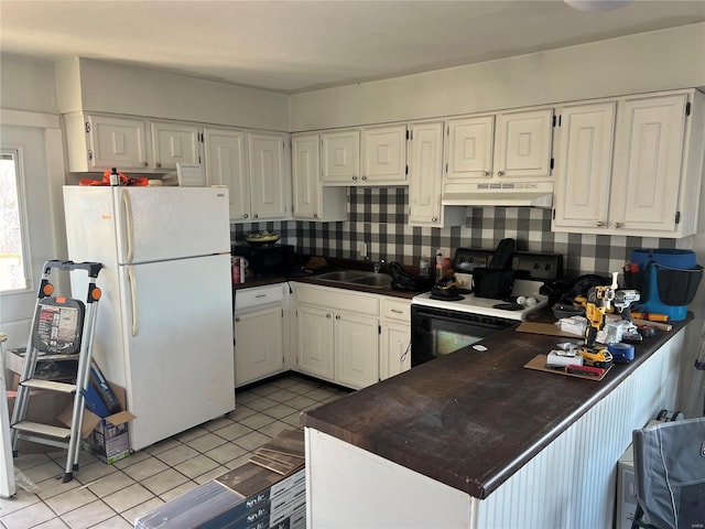 kitchen featuring electric stove, dark countertops, freestanding refrigerator, white cabinetry, and under cabinet range hood