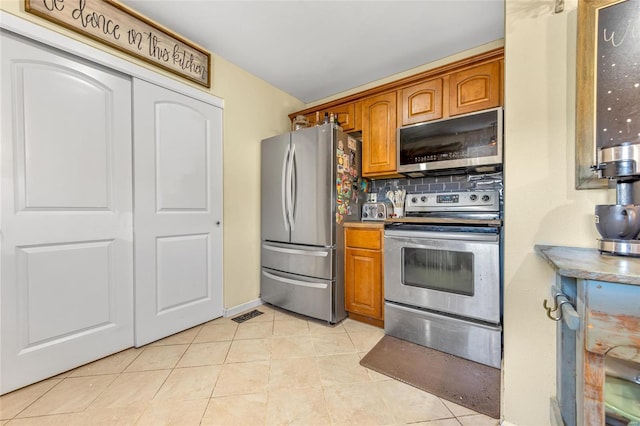 kitchen featuring backsplash, stainless steel appliances, and light tile patterned flooring