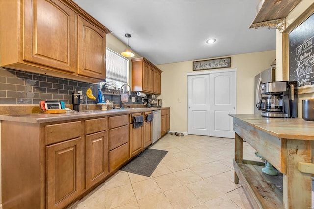 kitchen featuring light tile patterned floors, sink, dishwasher, hanging light fixtures, and tasteful backsplash