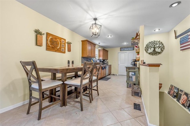 dining area featuring a notable chandelier and light tile patterned flooring