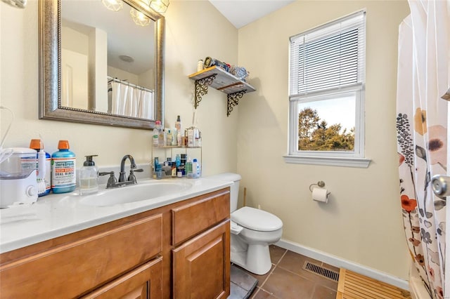 bathroom with tile patterned flooring, vanity, and toilet