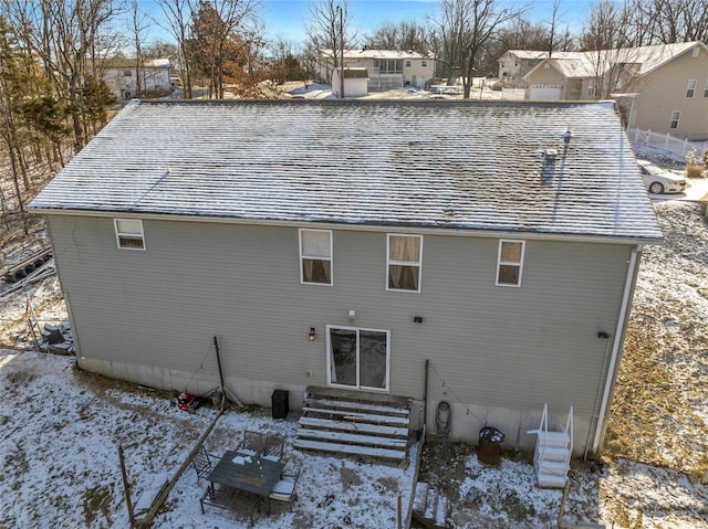 view of snow covered back of property