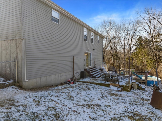 snow covered property with central AC