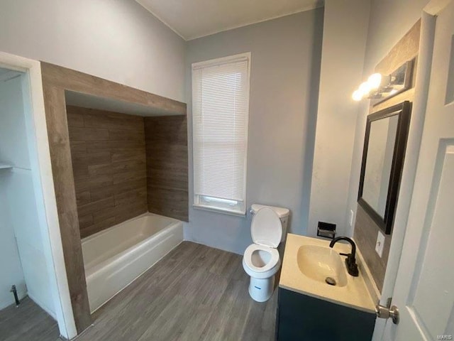 bathroom with vanity, a tub to relax in, wood-type flooring, and toilet