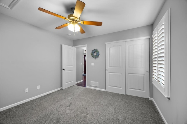 unfurnished bedroom featuring a ceiling fan, visible vents, baseboards, a closet, and dark carpet