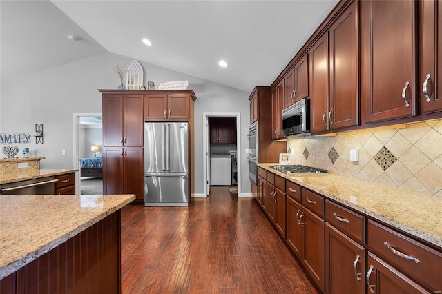 kitchen with stainless steel appliances, vaulted ceiling, and light stone countertops