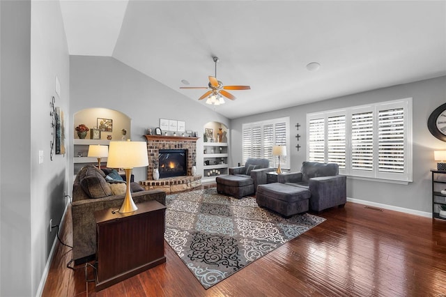 living area with ceiling fan, a fireplace, baseboards, vaulted ceiling, and hardwood / wood-style floors