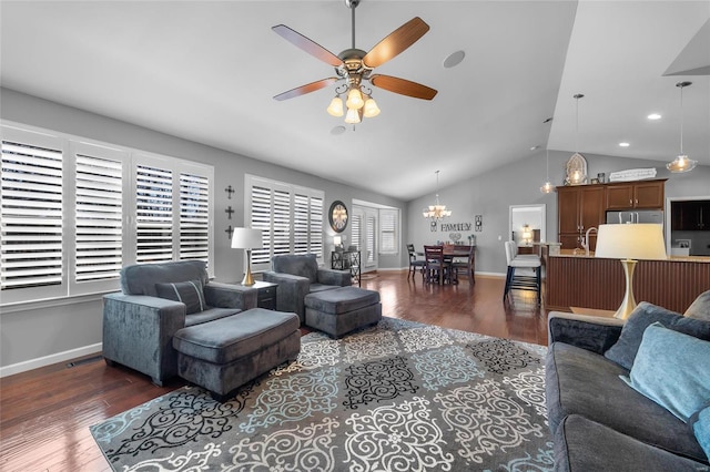 living room featuring vaulted ceiling, dark wood finished floors, baseboards, and ceiling fan with notable chandelier